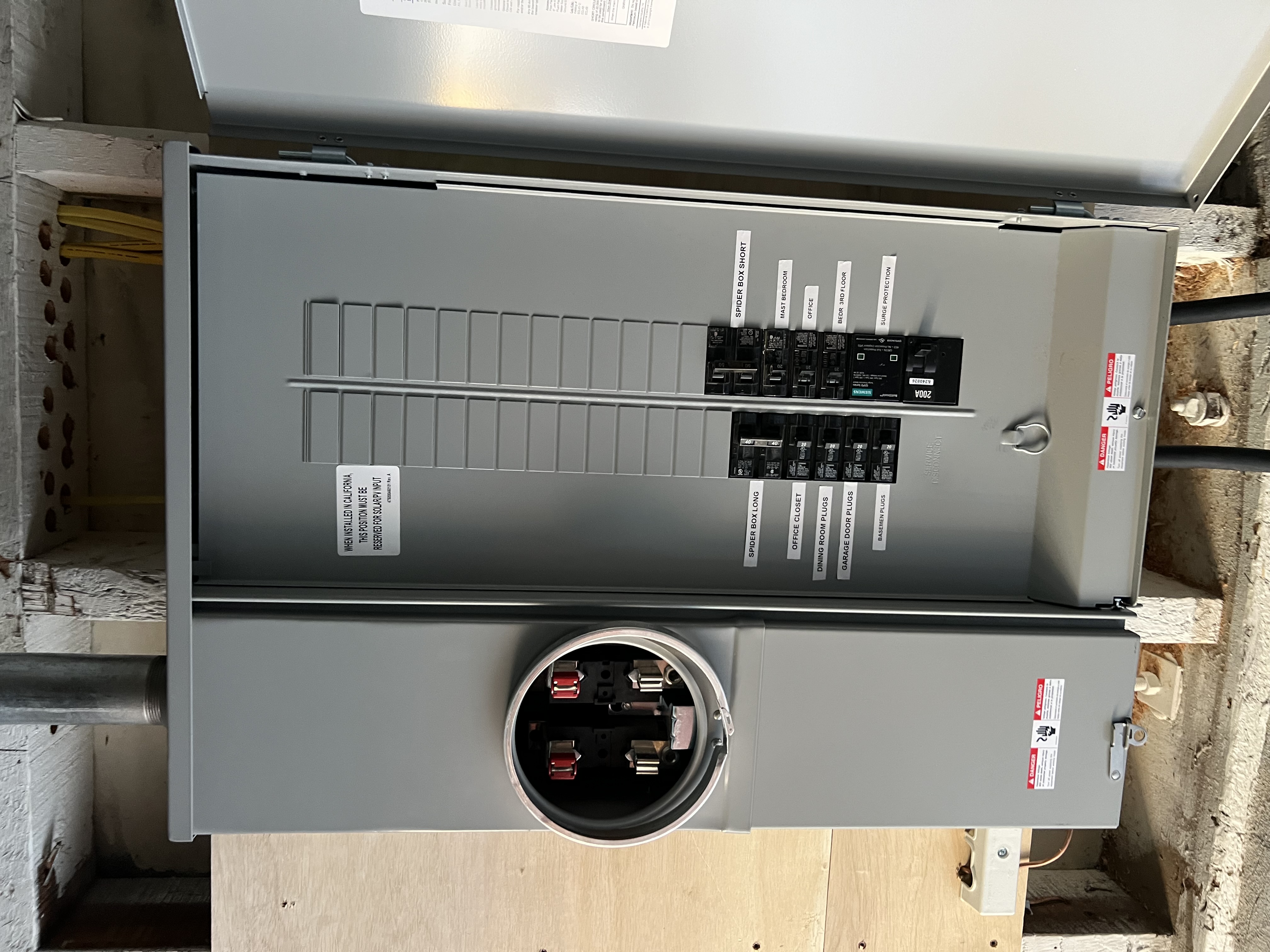 Professional 200-amp main electrical panel with meter socket installation and clean conduit work